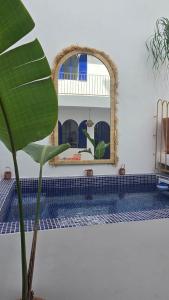 a bathroom with a mirror and a swimming pool at Riad house Lyabaïana,piscine climatisation, hammam, vue mer in Tangier