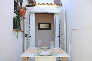 a table with a plate and wine glasses on it at Resolana 26 by SIERRA VIVA in Higuera de la Sierra