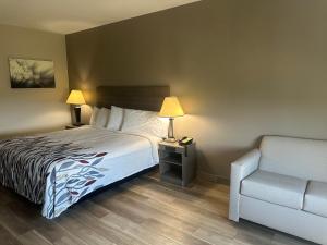 a hotel room with a bed and a chair at Red Roof Inn La Porte in La Porte