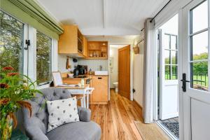 a living room with a couch and a kitchen at Badger Shepherds Hut in Hartfield