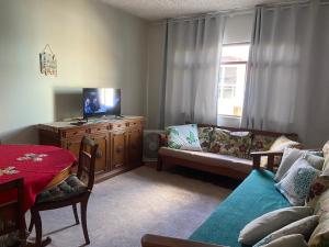 a living room with a tv and a couch at Apenas 50 metros da Prainha de Arraial do Cabo - excelente apartamento in Arraial do Cabo