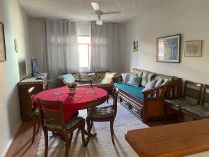 a living room with a table and a couch at Apenas 50 metros da Prainha de Arraial do Cabo - excelente apartamento in Arraial do Cabo