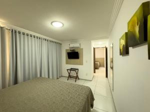 ein Schlafzimmer mit einem Bett und einem Fernseher in der Unterkunft Annamar Hotel in João Pessoa
