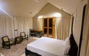 a bedroom with a bed and a desk in it at Enchanted Escapes Yala in Yala