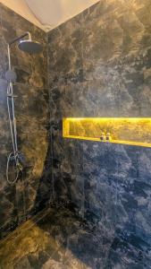 a bathroom with a shower with a stone wall at Enchanted Escapes Yala in Kirinda +14 photos