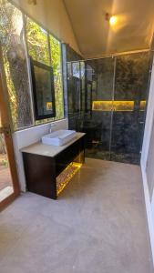 a bathroom with a sink and a shower at Enchanted Escapes Yala in Kirinda