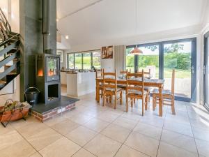 a kitchen and dining room with a table and a wood stove at 2 Bed in Okehampton 75708 in Sampford Courtenay