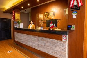 a woman standing behind a bar in a restaurant at Hotel Royal Qosqo in Cusco