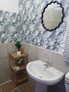 a bathroom with a sink and a mirror at KHAHILIGI Guest House in Roodepoort +102 photos