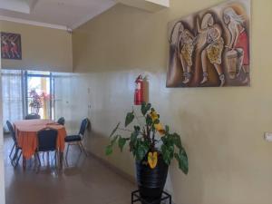 a dining room with a table and a potted plant at Glory Motel by HODAC LTD in Kigali