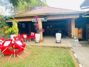a group of red chairs and tables in front of a restaurant at Glory Motel by HODAC LTD in Kigali