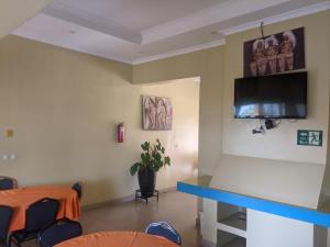 a room with a table and a tv on the wall at Glory Motel by HODAC LTD in Kigali