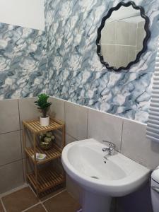 a bathroom with a sink and a mirror at KHAHILIGI Guest House in Roodepoort