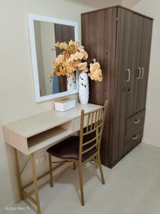 a desk with a mirror and a vase with flowers at Louisse 223 Avida in Molo
