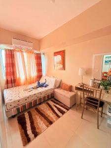 a living room with a couch and a table and a desk at Louisse 223 Avida in Molo