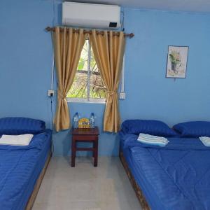 a living room with two beds and a window at Chamka Sne LyLy Resort in Phumĭ Stœ̆ng Chral
