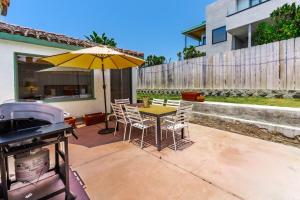 a patio with a table with an umbrella and a grill at 2BR-2 mins to Ocean-Sleeps 8-Pets in San Diego