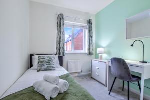 a bedroom with a bed and a desk and a chair at 4Bed 3 Bath Home I Sleeps 7-9 I Family & Contractors I Parking in Kempston