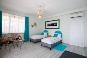 a room with two beds and a table and chairs at La Fonte Creativa in Caprino Veronese