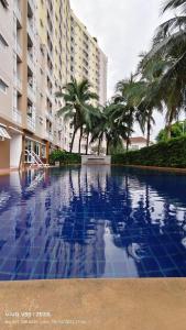 a swimming pool with palm trees and a building at No 498 SPD in Phuket Town