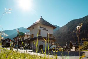 a building on a hill with mountains in the background at Dorf Loft Montafon by Pferd auf Wolke in Gaschurn