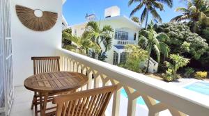 balcón con mesa y sillas junto a la piscina en Mermaid Cove - GARDEN, en Blue Bay