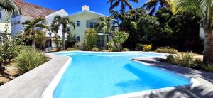 a swimming pool in front of a house at Mermaid Cove - GARDEN in Blue Bay