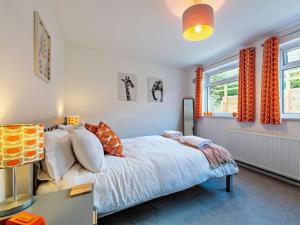 una camera da letto con letto e tende arancioni di 2 Bed in Bude 80589 a Poughill
