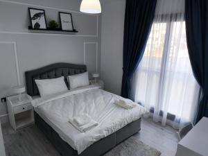 a bedroom with a bed with two towels on it at Caesar Blue Resort & Spa apartment D10 in Kalecik +20 photos