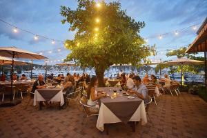 a group of people sitting at tables in a restaurant at AltaVista 4C 3 bdr Ocean View in Los Suenos in Herradura