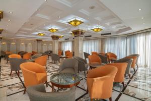 une grande pièce avec des tables, des chaises et des fenêtres dans l'établissement JAZ Pyramids Resort, au Caire
