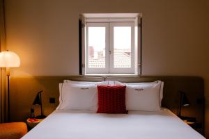 a bedroom with a bed with white sheets and a window at Casa Zogbi Hotel in Porto +59 photos
