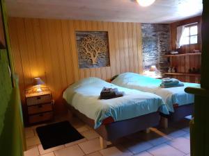 Un dormitorio con dos camas y un cuadro de un árbol en la pared. en De Patuljak, en Houffalize 44 fotos más