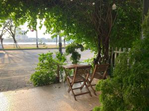 a wooden table and bench next to a tree at Vitalis Riverside Hotel in Danang