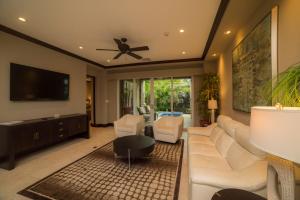 a living room with a white couch and a ceiling fan at Vista Bahia 3D 3 bdr Ocean View in Los Suenos in Herradura