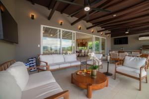 a living room with white couches and a table at Casa Ohana 5 bdrs ocean view in Los Suenos in La Mona