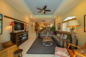 a living room with a couch and a tv at Colina 8E 2 bdr Garden View in Los Suenos in Isla Herradura