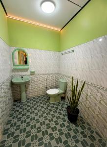 Un baño con lavabo, inodoro y espejo. en The bunker Hostal - Ella Srilanka, en Ella