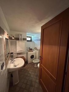 une salle de bain avec un lavabo et des toilettes et une porte dans l'établissement La Marmotta, à Rollieres