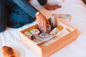 a person sitting on a bed with a tray of food at Five Sabrosa Senses in Sabrosa