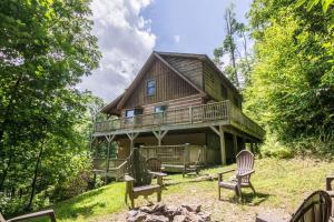 une grande maison en bois avec des bancs devant elle dans l'établissement 2 Cubs Cabin, à Blowing Rock