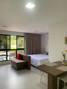 a bedroom with a bed and a desk and a table at Loft completo in Blumenau