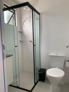 a bathroom with a toilet and a glass shower at Loft completo in Blumenau +12 photos
