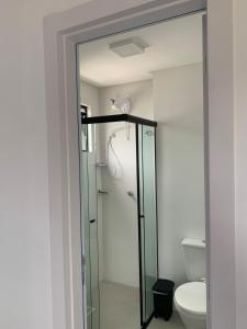 a glass shower in a bathroom with a toilet at Loft completo in Blumenau