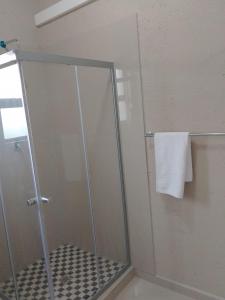 a shower with a glass door in a bathroom at Bear Haven Lodge in Manguzi +1 photo