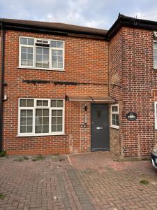 a brick house with a door and a brick driveway at En-suite studios near Wembley Stadium in Northwood