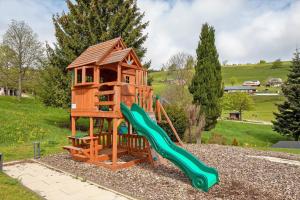 a tree house with a slide and a playground at Villa Skylodges mit 9 Wohnungen in Hofsgrund