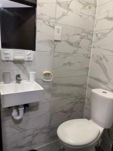 a bathroom with a white toilet and a sink at En-suite studios near Wembley Stadium in Northwood