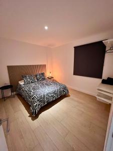 ein Schlafzimmer mit einem Bett und einem großen Bildschirm in der Unterkunft Apartamento Familiar in La Cuesta