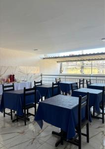 a group of tables and chairs with blue tables at SOL BRASIL HOTEL e POUSADA in Fortaleza